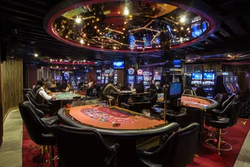 A close-up shot of golden coins falling around a spinning roulette wheel, representing immersive casino action at VK8.